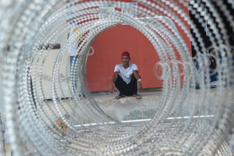 TOPSHOTS This picture taken in Langsa on May 24, 2015 shows a Bangladeshi migrant sitting at a shelter. Indonesia has begun search and rescue operations for stranded migrant boats carrying Bangladeshis and ethnic Rohingya from Myanmar, an official said