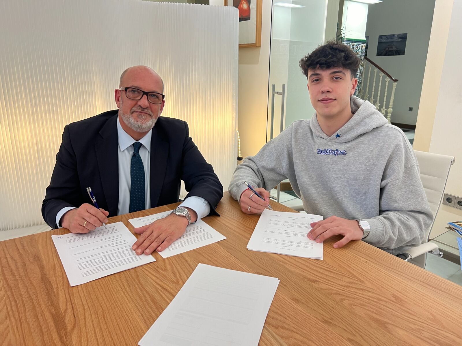 El presidente del Trops Málaga Alberto Camas y Víctor Barderas, firmando su nuevo contrato profesional