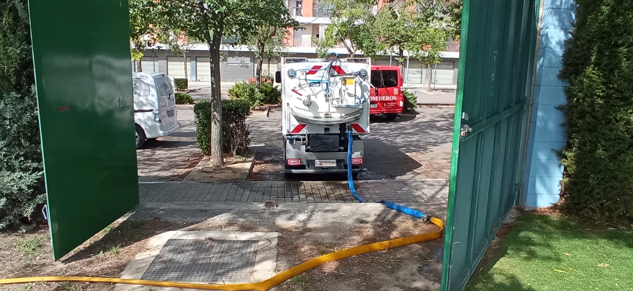 Limpiadora cargando agua de las piscinas municipales en Huesca