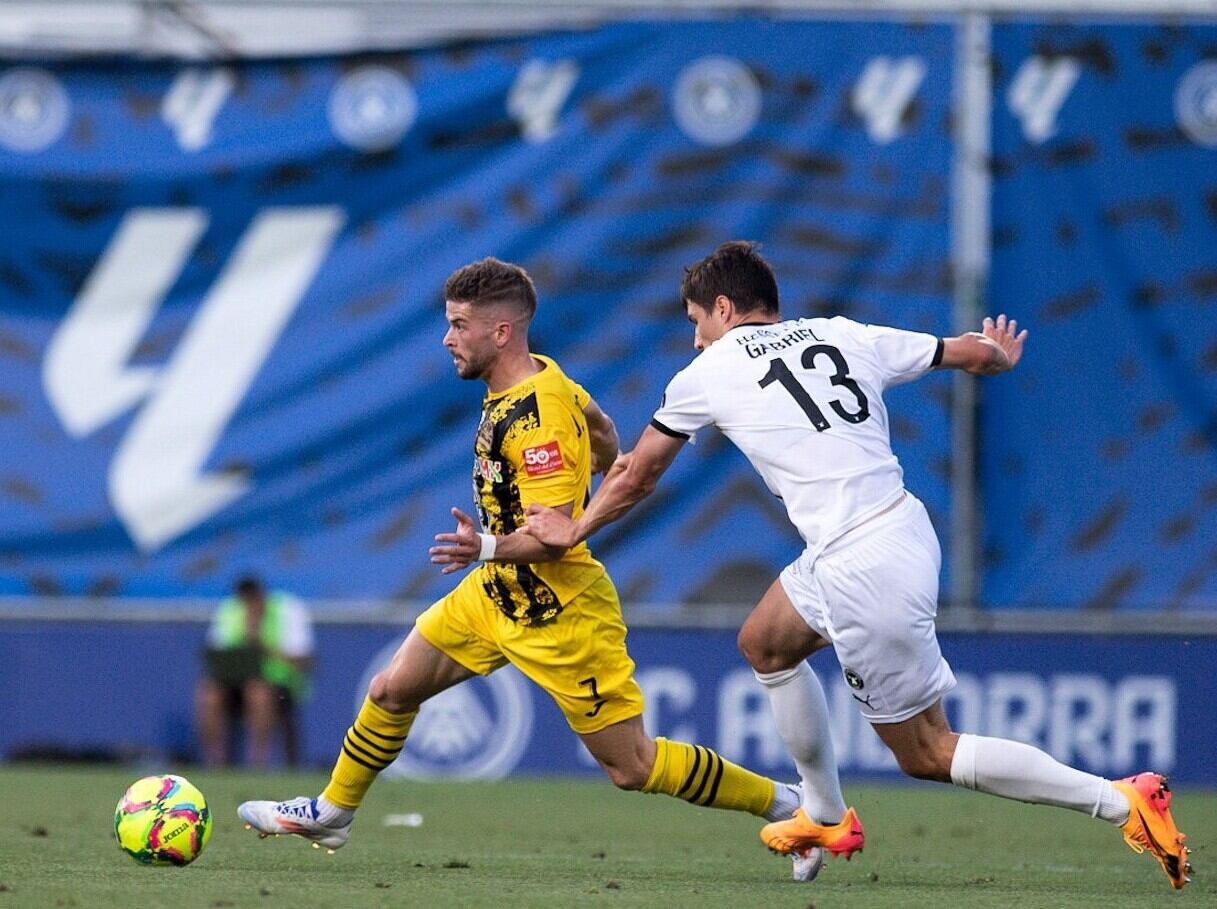 El jugador local, Jorge Bolívar, conduint l'esfèric davant el seu rival en el partit d'ahir