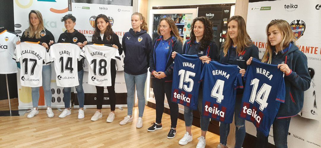 Las entrenadoras y jugadoras del Valencia y del Levante posan con las camisetas de sus equipo.