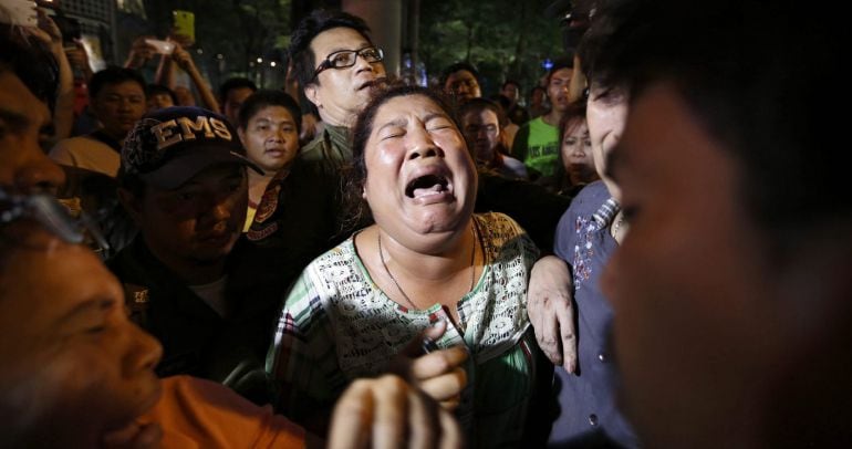 Varias personas buscan a sus familiares en el lugar donde ha explosionado una bomba frente a un templo budista en Bangkok, Tailandia.