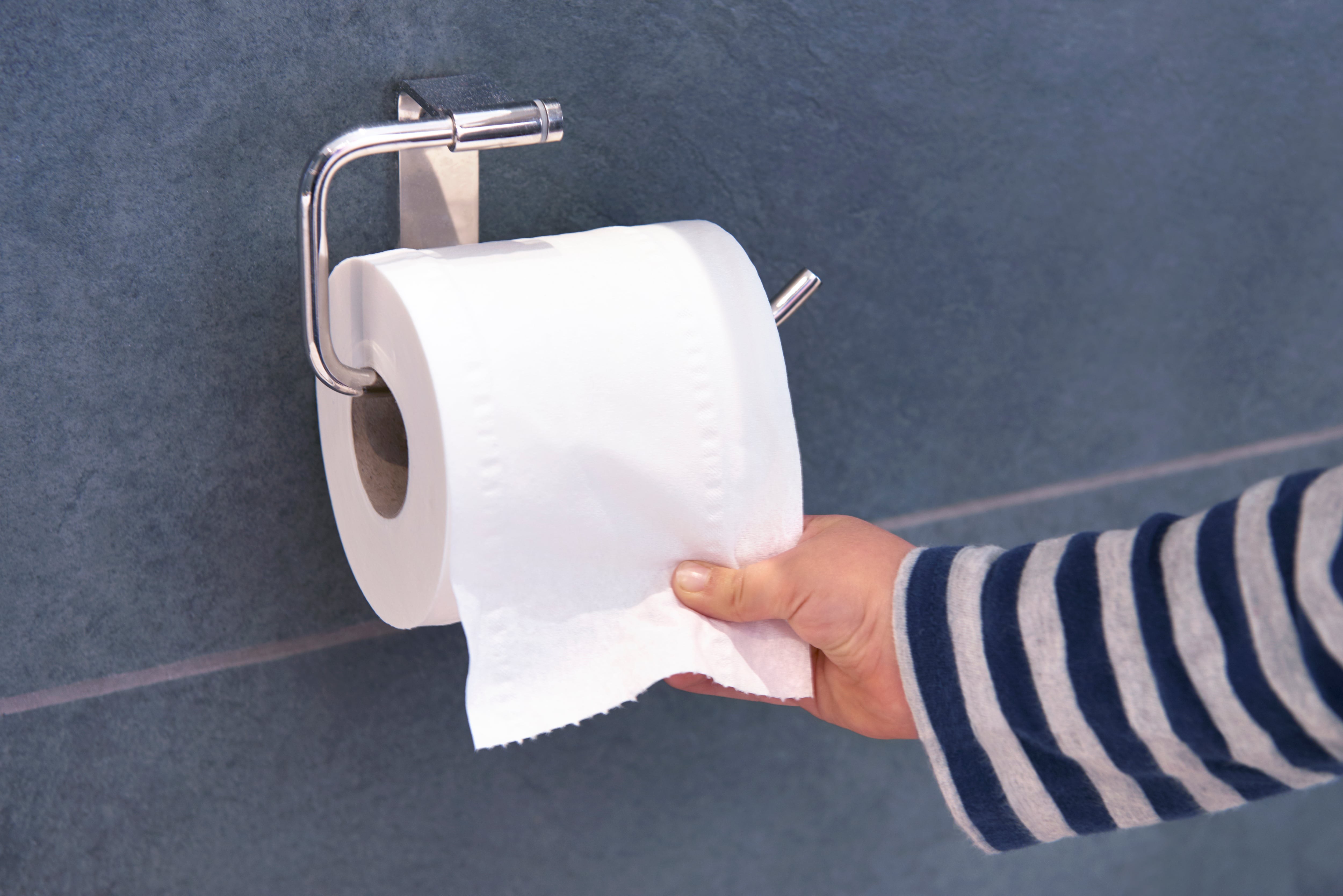 Un niño cogiendo un rollo de papel higiénico.