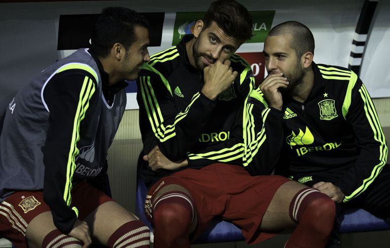 Piqué, junto a Pedro y Jordi Alba en el banquillo de la selección española.