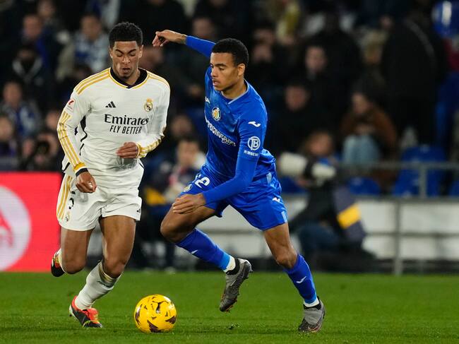 Mason Greenwood y Jude Bellingham disputan el balón