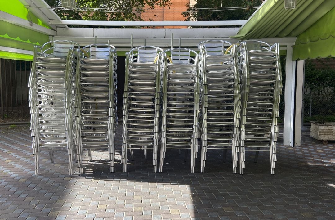 Sillas apiladas en la terraza de un bar.