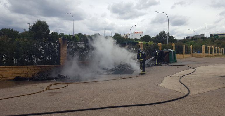 Dos bomberos apagan el incendio originado junto al punto limpio.
