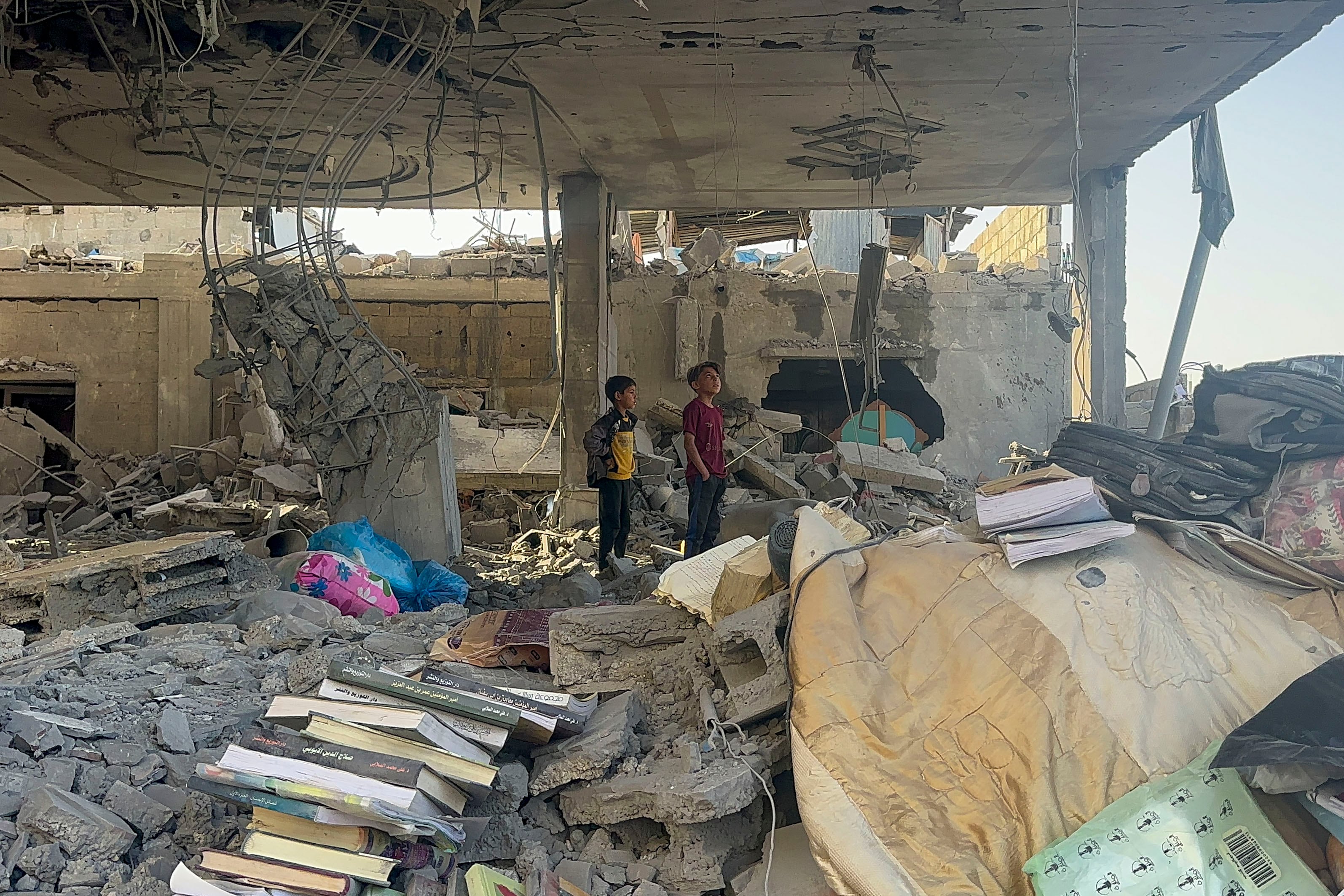 niños mirando desolados los restos del bombardeo israelí que ha destruido los restos de su casa en la Franja