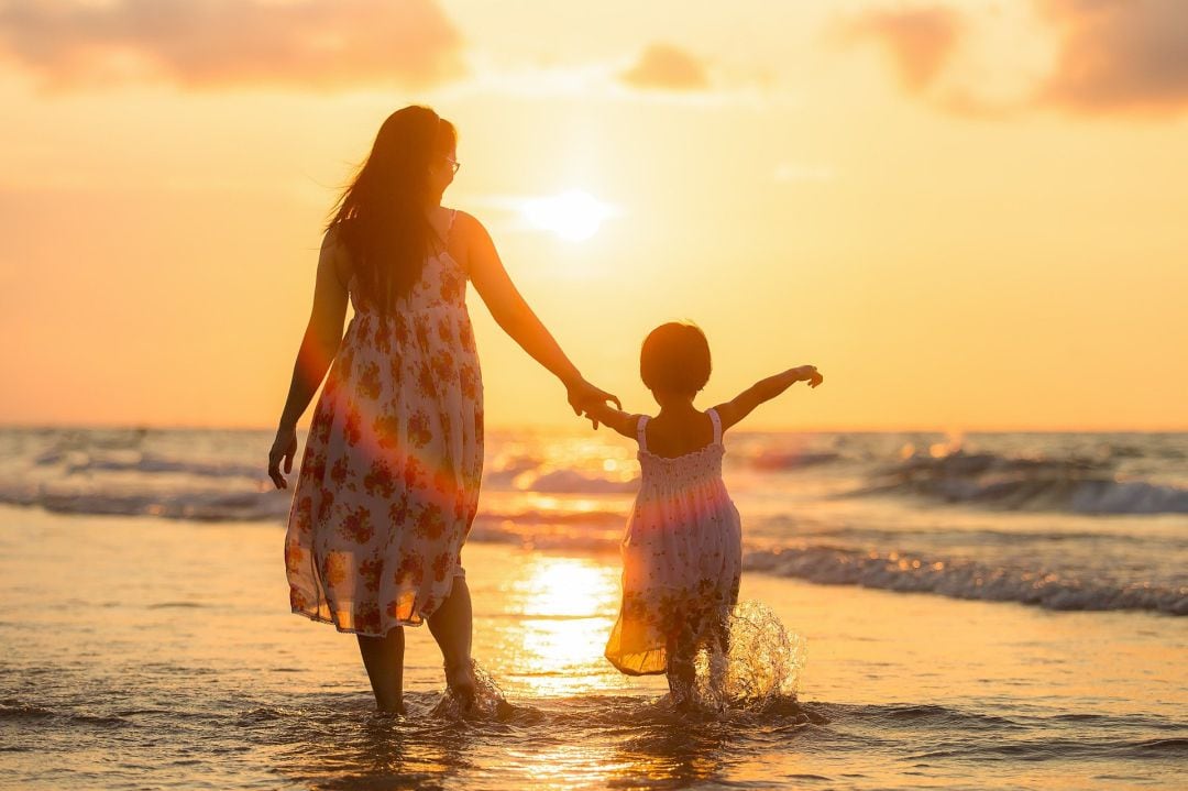 Una madre con su hija en la playa