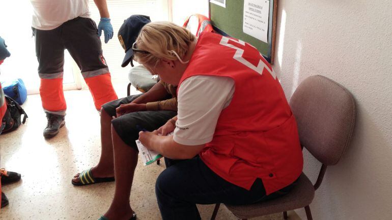 Personal de Cruz Roja atendiendo a uno de los inmigrantes