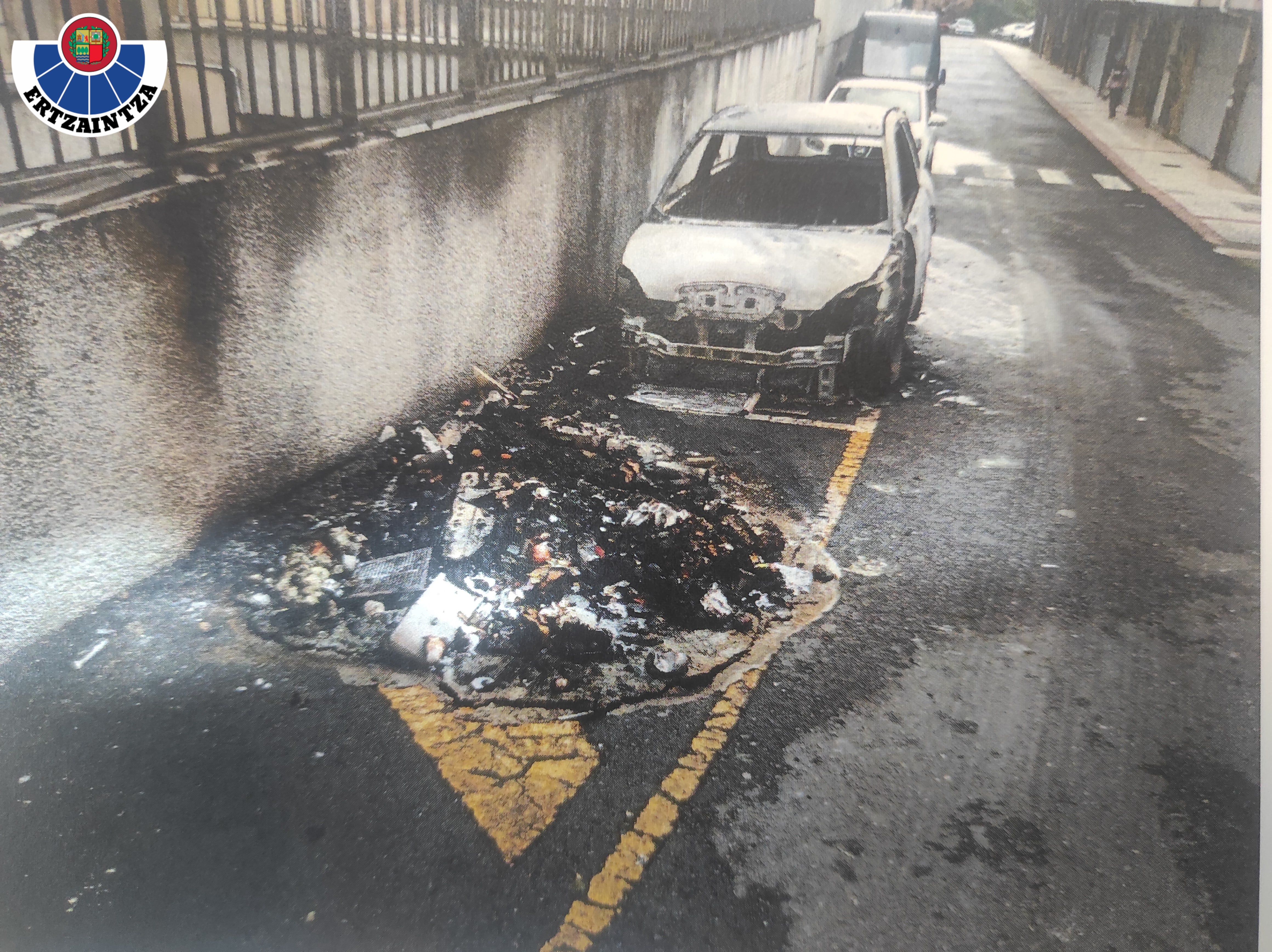 El vehículo y uno de los contenedores calcinadores en el incendio provocado de Balmaseda. / Ertzaintza