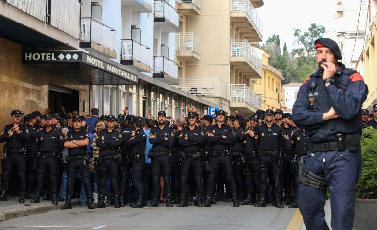 Un mosso y un grupo de policías nacionales, frente a un hotel de Pineda de Mar.