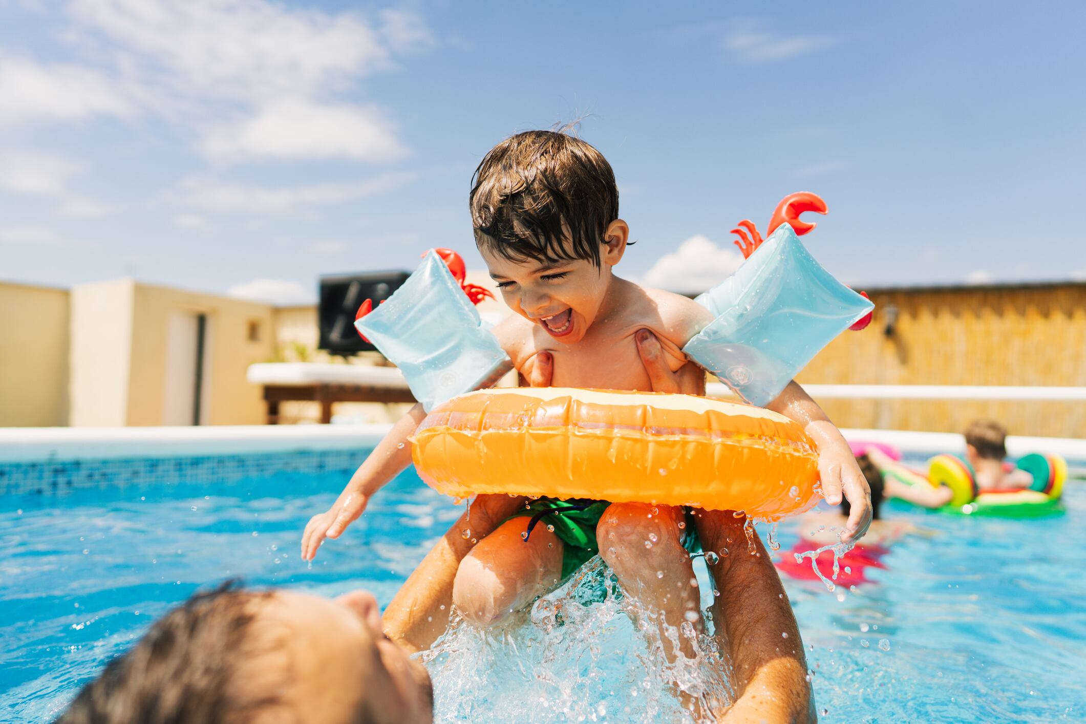 Un niño con manguitos y flotador en el agua.