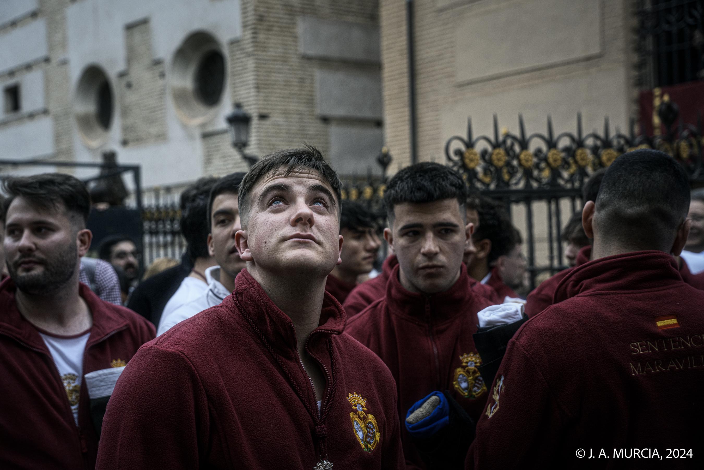 Un costalero de Sentencia y Maravillas mira al cielo tras suspenderse la salida procesional de este Domingo de Ramos en la Semana Santa de Granada de 2024