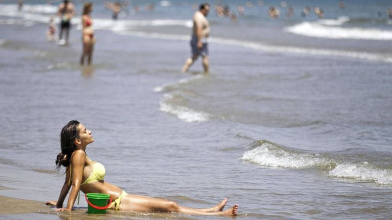 Una mujer descansa en la orilla de la playa. 