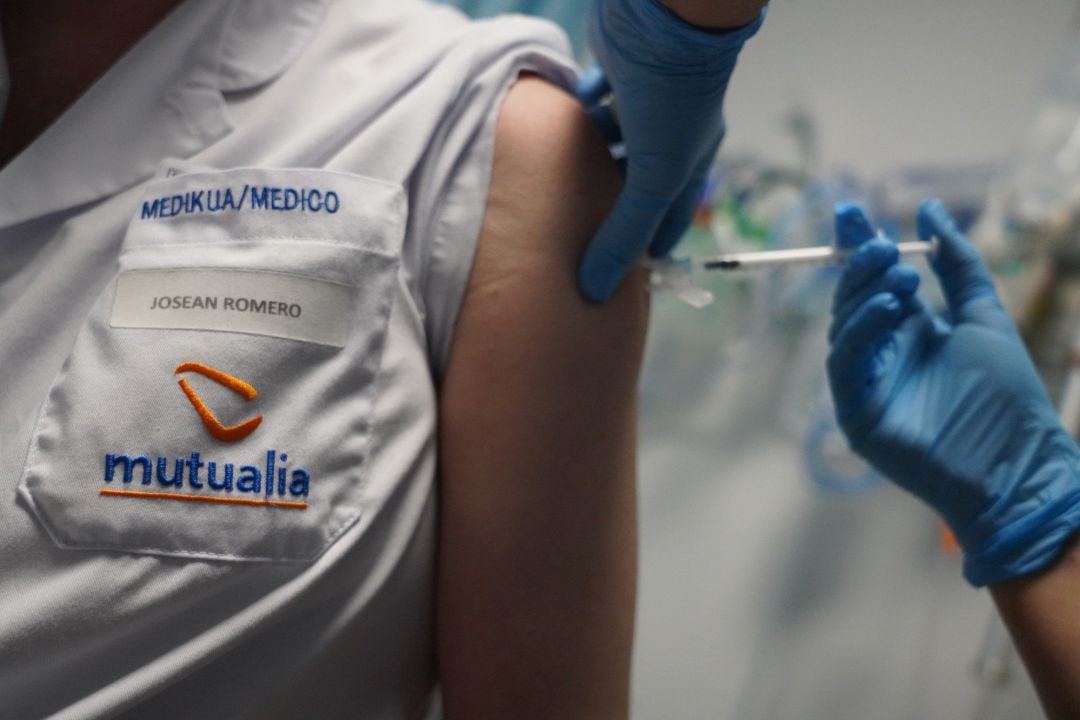 Un sanitario vacuna a un médico de la clínica contra el Covid-19