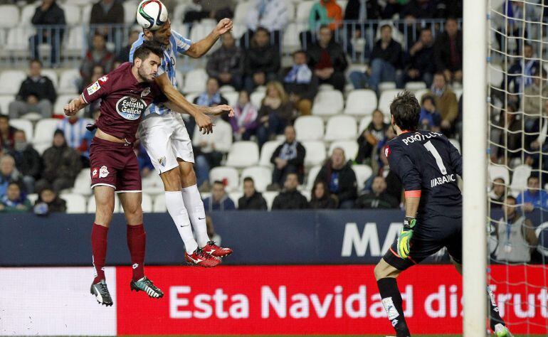 El delantero paraguayo del Málaga Roque Santa Cruz cabecea un balón ante Pablo Insúa.