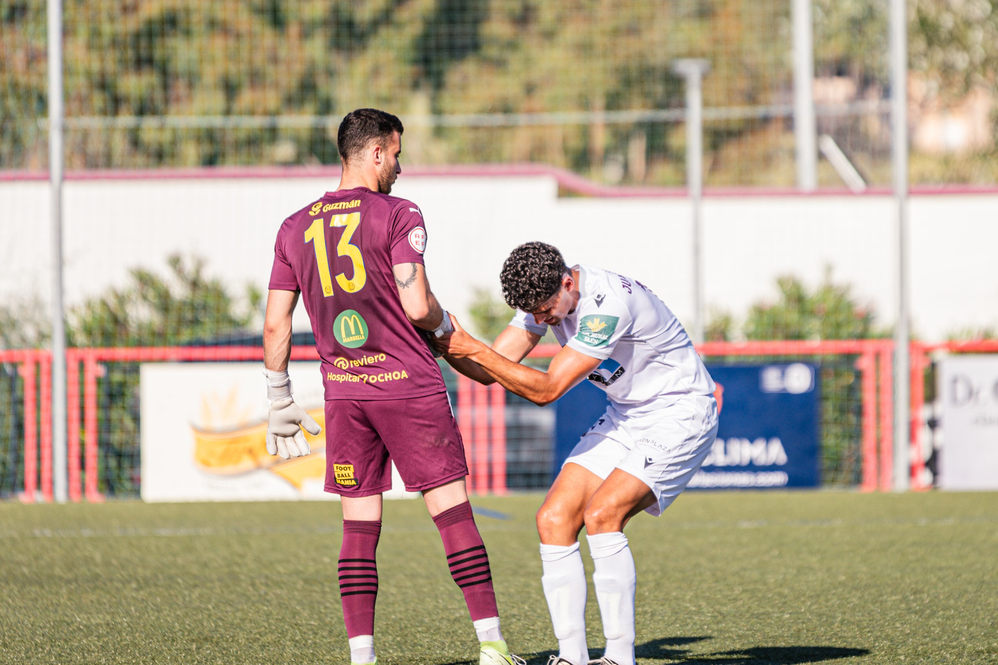 Joel, portero del Marbellí, levanta a Juanma Porro, jugador del Real Jaén.