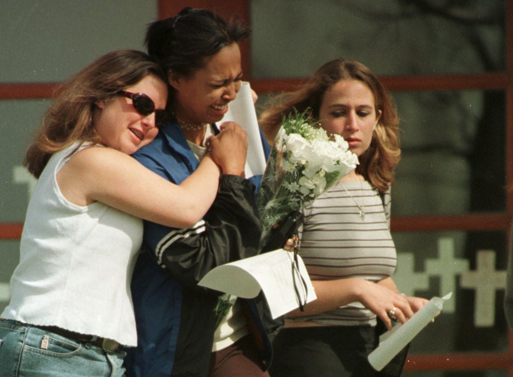 Compañeros de los 12 estudiantes asesinados el 20 de abril de 1999 en la Escuela Secundaria de Columbine lloran después de conocer el suceso.