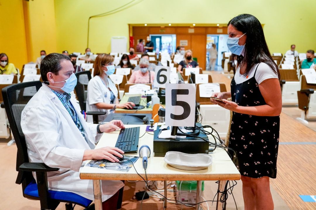 Una mujer entrega su documentación para recibir la primera dosis de la vacuna de Pfizer-BioNTech contra el Covid-19, a 9 de junio de 2021, en el Hospital Severo Ochoa de Leganés.