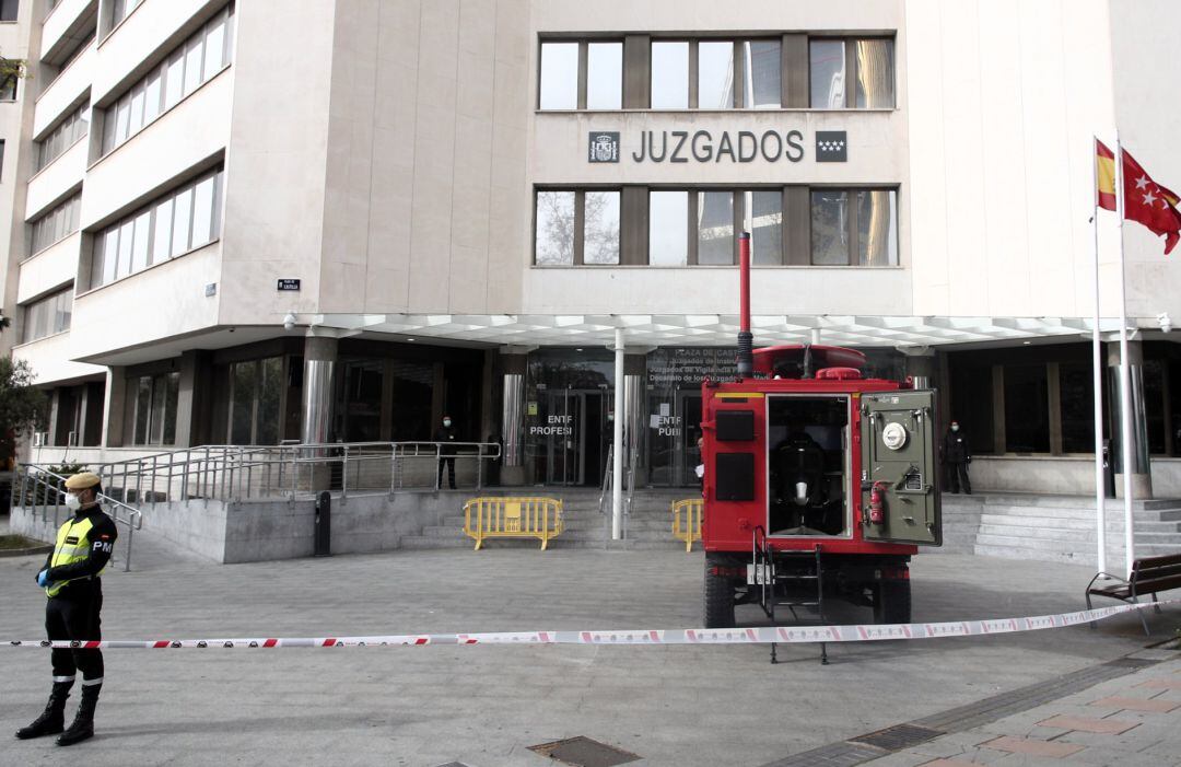 Un militar de la UME vigila fuera de los juzgados ordinarios de Plaza Castilla y de Familia donde durante la jornada de hoy los efectivos militares llevarán a cabo labores de desinfección debido a la afluencia de público al estar abierta estas sedes para diligencias urgentes, en Madrid (España)