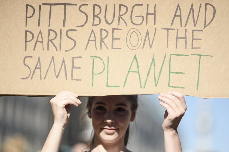 Una manifestante sostiene una pancarta en la que se lee &#039;Pittburgh y París están en el mismo planeta&#039;, durante las protestas contra la salida de Estados Unidos del Acuerdo de París