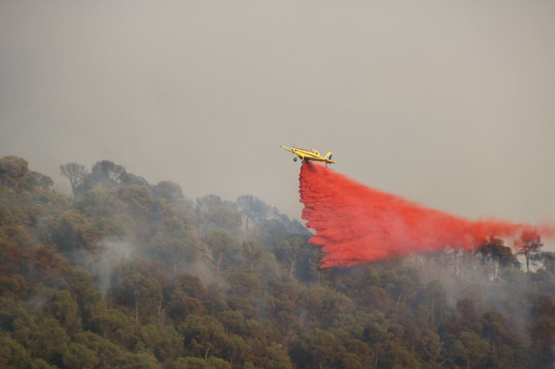 Un helicóptero participa en las labores de extinción de un incendio forestal en Cataluña. 