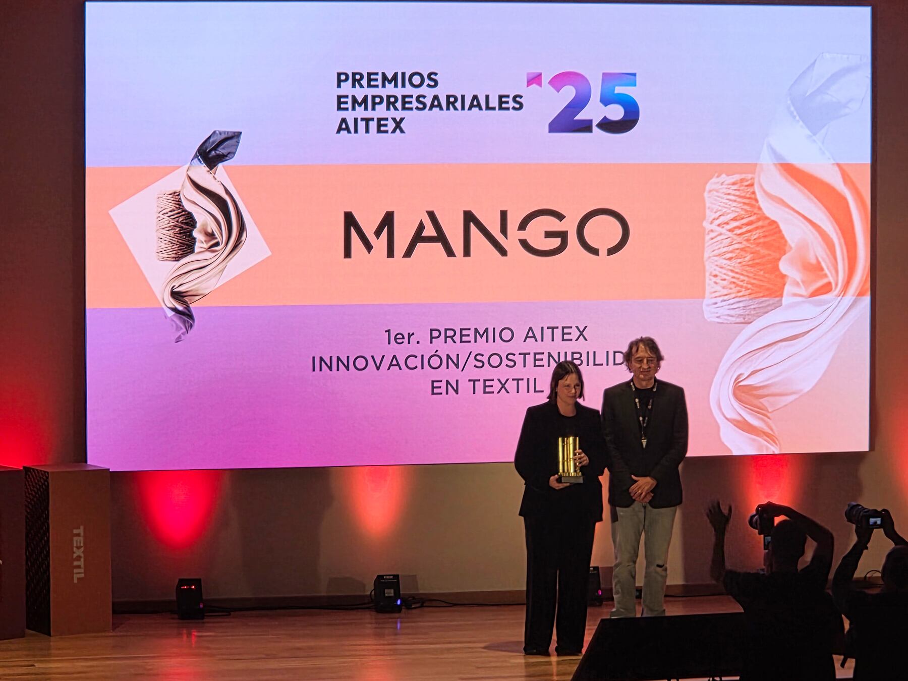 Instante en el que el presidente de Aitex, León Grau, entrega el premio de ganador a Mónica Caro, representante de Mango