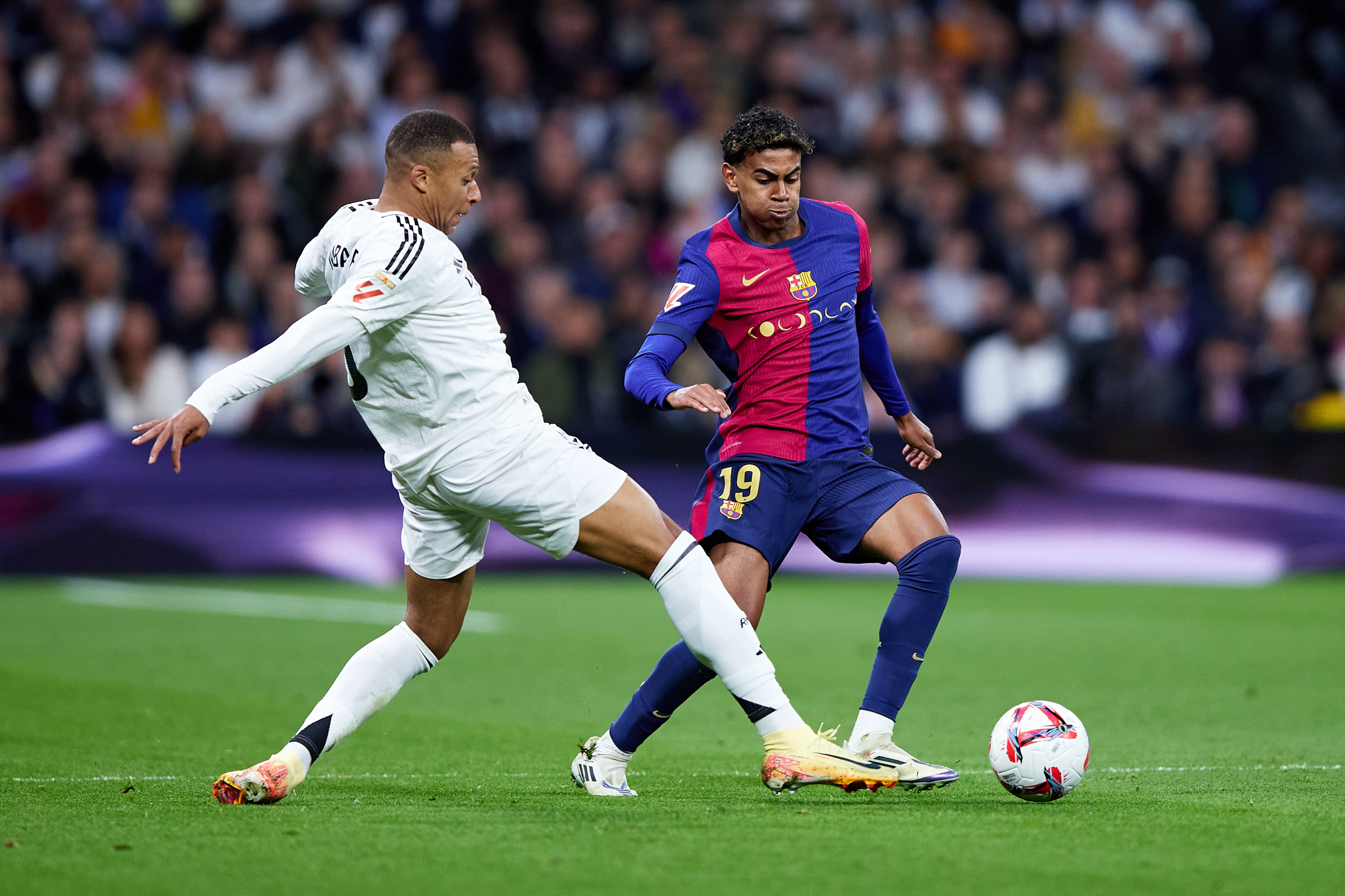 MADRID, SPAIN - OCTOBER 26: Lamine Yamal of FC Barcelona competes for the ball with Kylian Mbappe of Real Madrid during the LaLiga match between Real Madrid CF and FC Barcelona at Estadio Santiago Bernabeu on October 26, 2024 in Madrid, Spain. (Photo by Alvaro Medranda/Quality Sport Images/Getty Images)