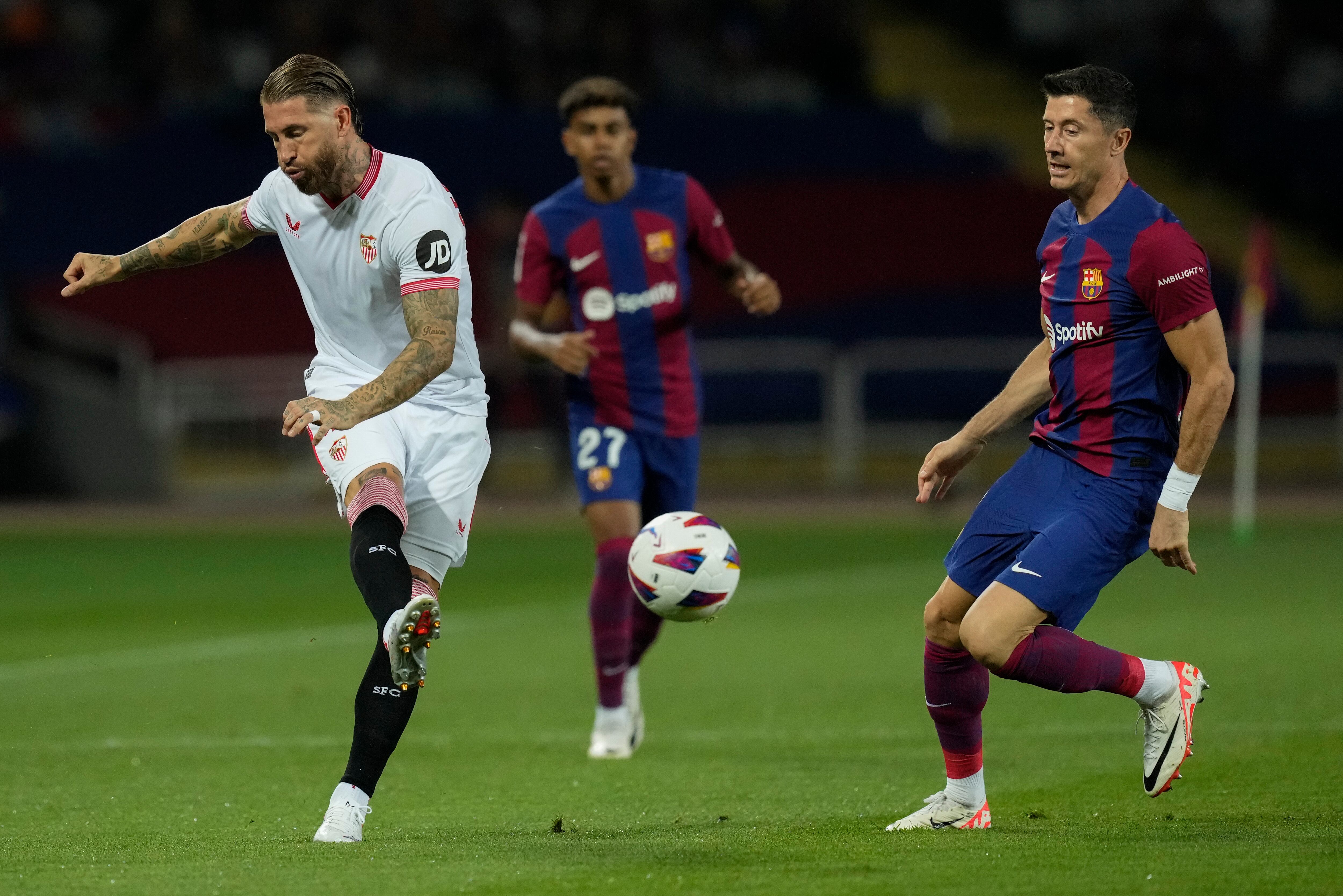 Sergio Ramos y Robert Lewandowski durante el partido de la primera vuelta de LaLiga EA Sports entre FC Barcelona y Sevilla FC. EFE/ Enric Fontcuberta