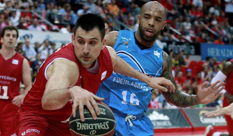 El ala pívot serbio del Tecnyconta Zaragoza, Milko Bjelica (i), protege el balón ante la presencia del base venezolano del Montakit Fuenlabrada, Gregory Vargas, durante el parido correspondiente a la jornada 33 de Liga Endesa en el Pabellón Príncipe Felip