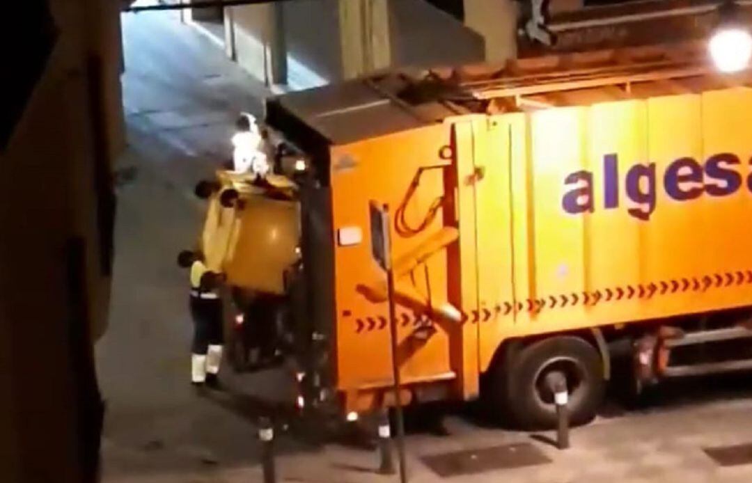 Momento en el que los operarios de Algesa vuelcan el contenedor amarillo en el camión de recogida de basura orgánica