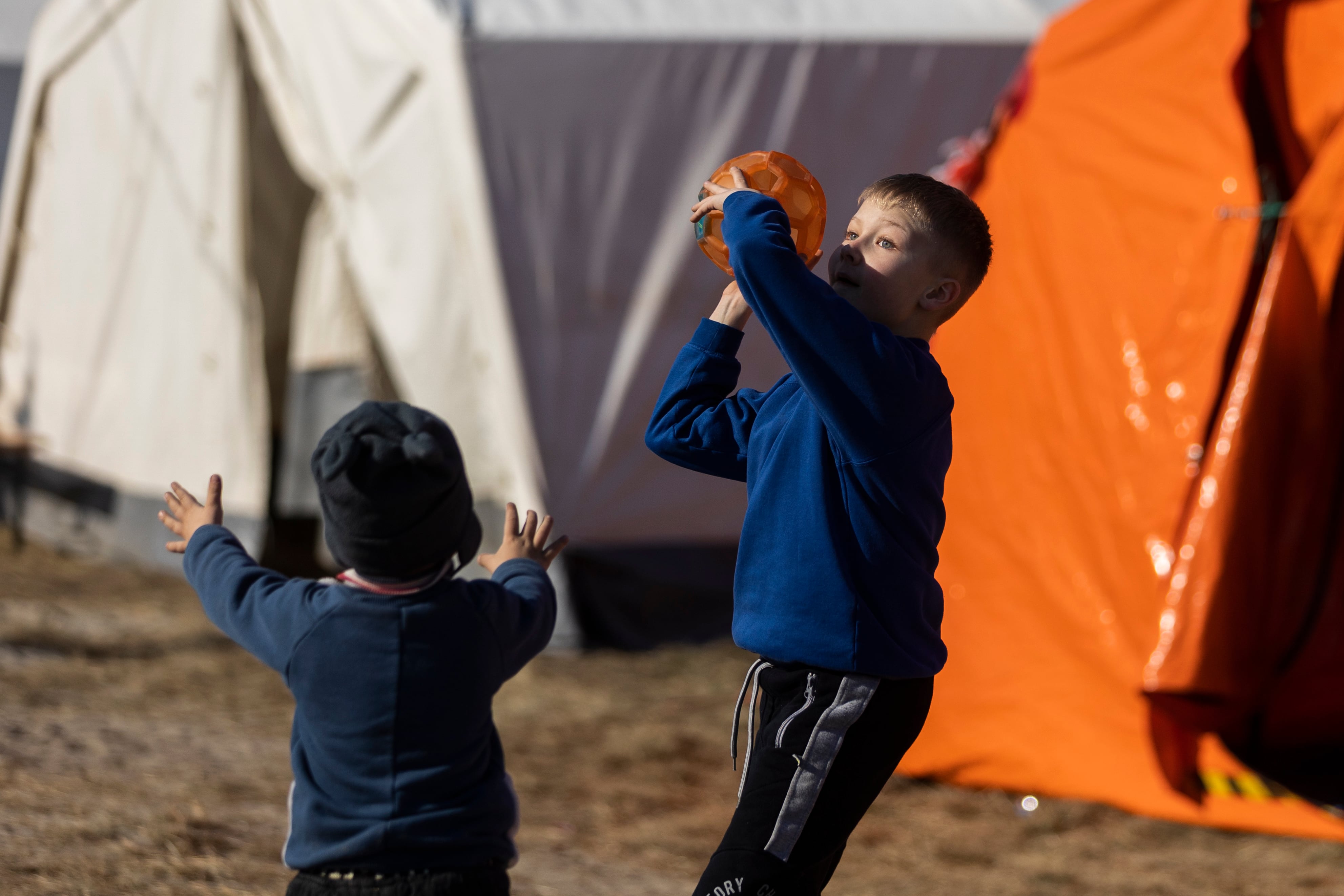 BUDOMIERZ (POLONIA), 14/03/2022.- Dos niños juegan este lunes en el campamento de refugiados en Budomierz (Polonia)