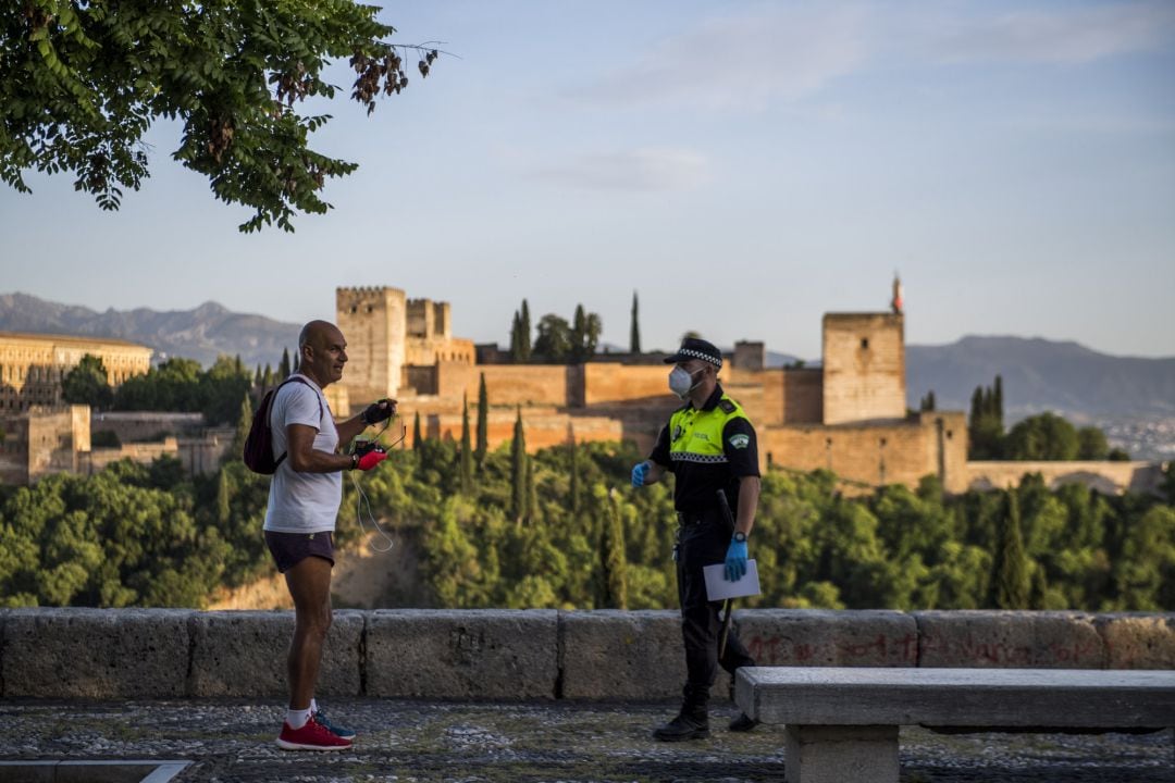 Un policía habla en Granada con un corredor