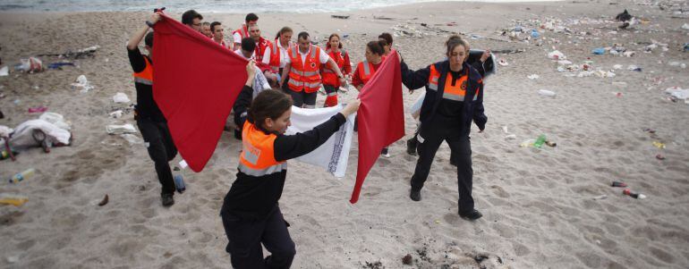 Agentes de la Policía Local de A Coruña y miembros de los equipos de Emergencias traslada a uno de los agentes que ha resultado herido tras un arriesgado rescate de un joven que se bañaba en la playa del Orzán.