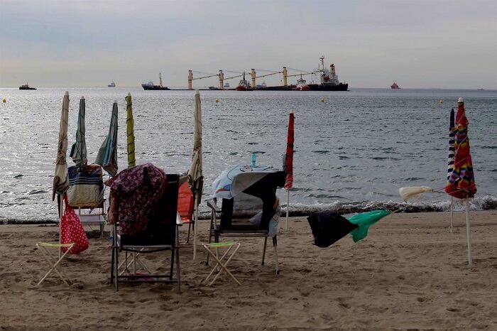 Personas en la playa observan los trabajos