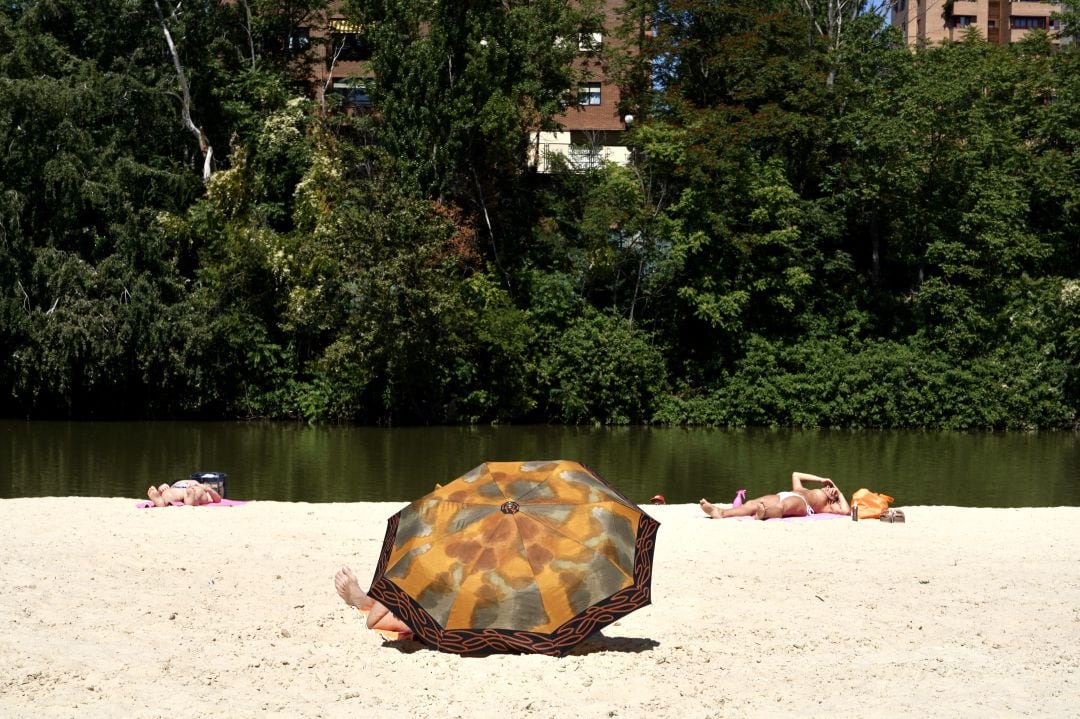 Gente tomando el sol en la playa vallisoletana de las moreras