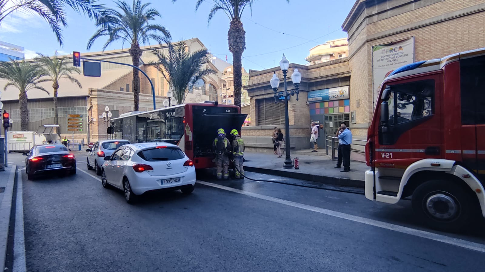 Momento en el que los bomberos sofocan el incendio en el motor del autobús