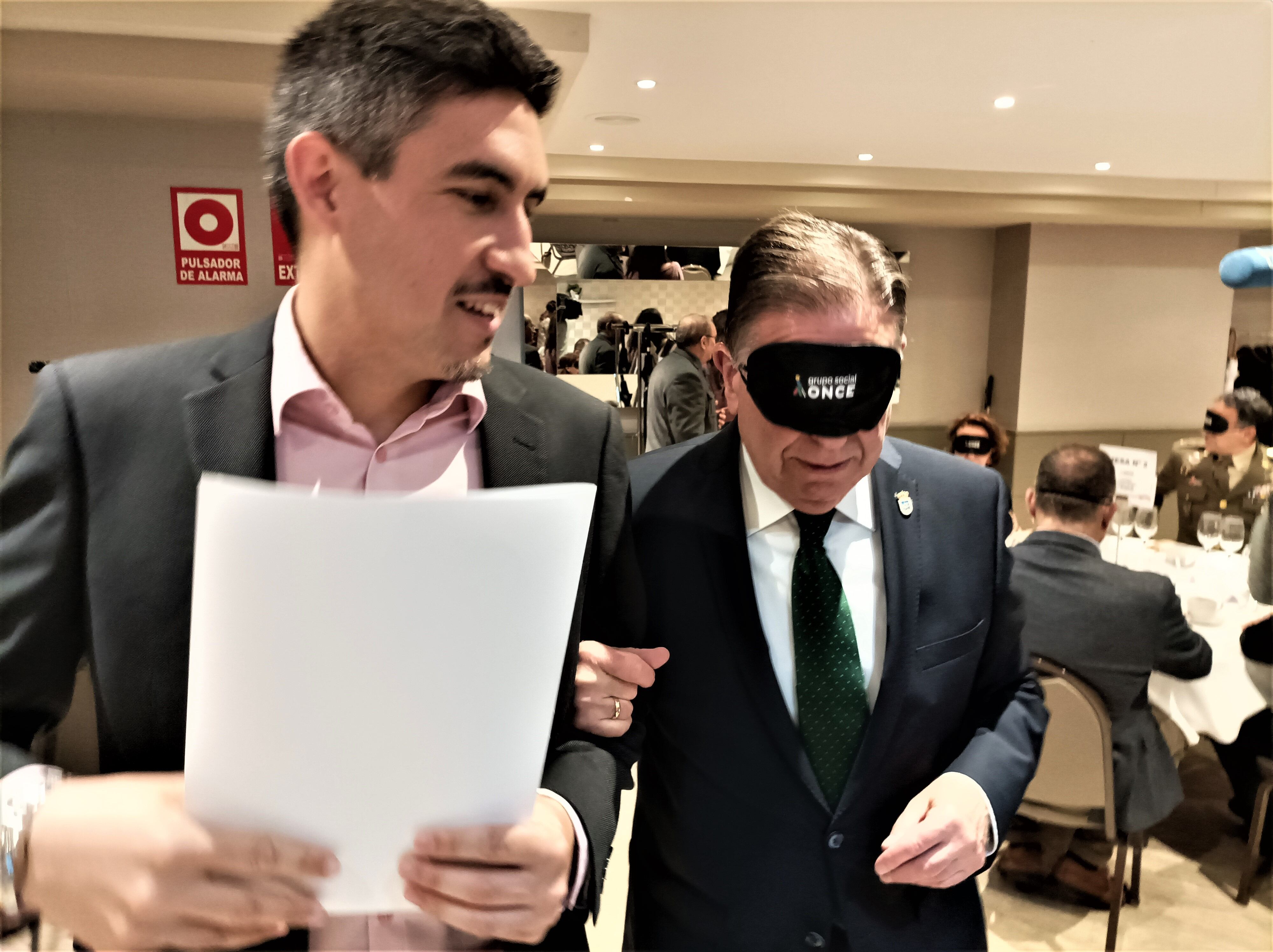 El alcalde de Oviedo, Alfredo Canteli, es conducido a su mesa por personal de la ONCE