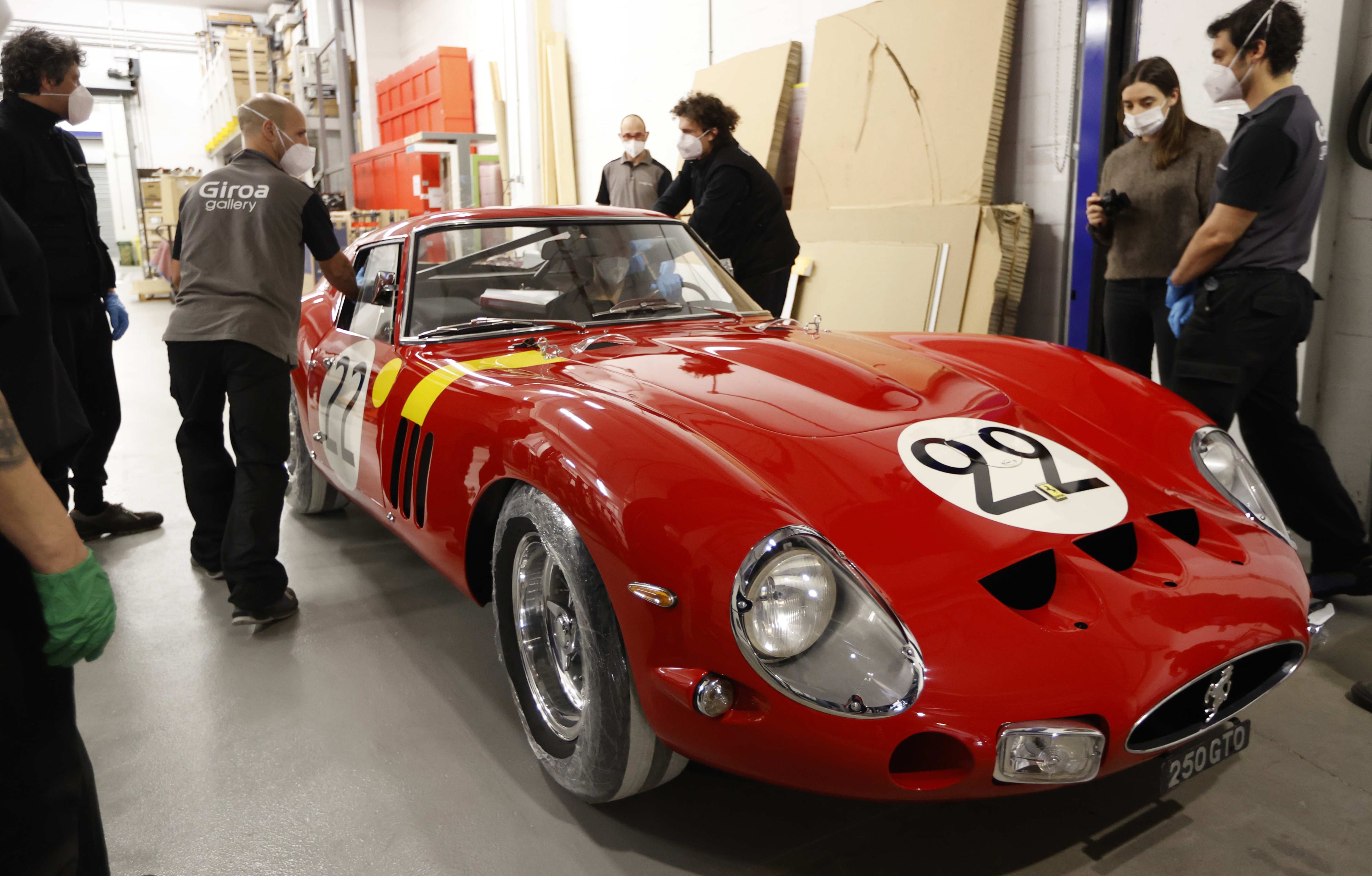 Operarios introducen en el museo Guggeheim de Bilbao el coche "Ferrari 250 GTO, 1962" que forma parte de una exposición. EFE/LUIS TEJIDO