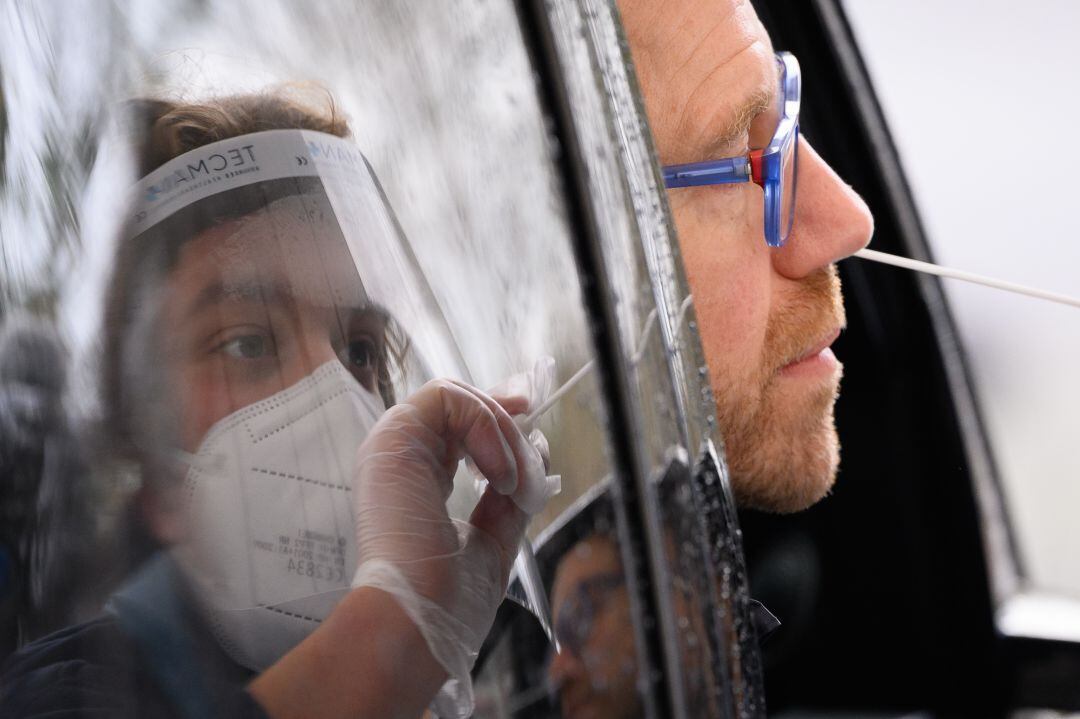 Un hombre se somete a una prueba PCR en su coche. 