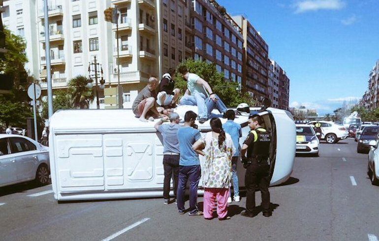 Varios vecinos ayudan a la Policía a rescatar a los ocupantes de una furgoneta que ha volcado en la avenida del Cid