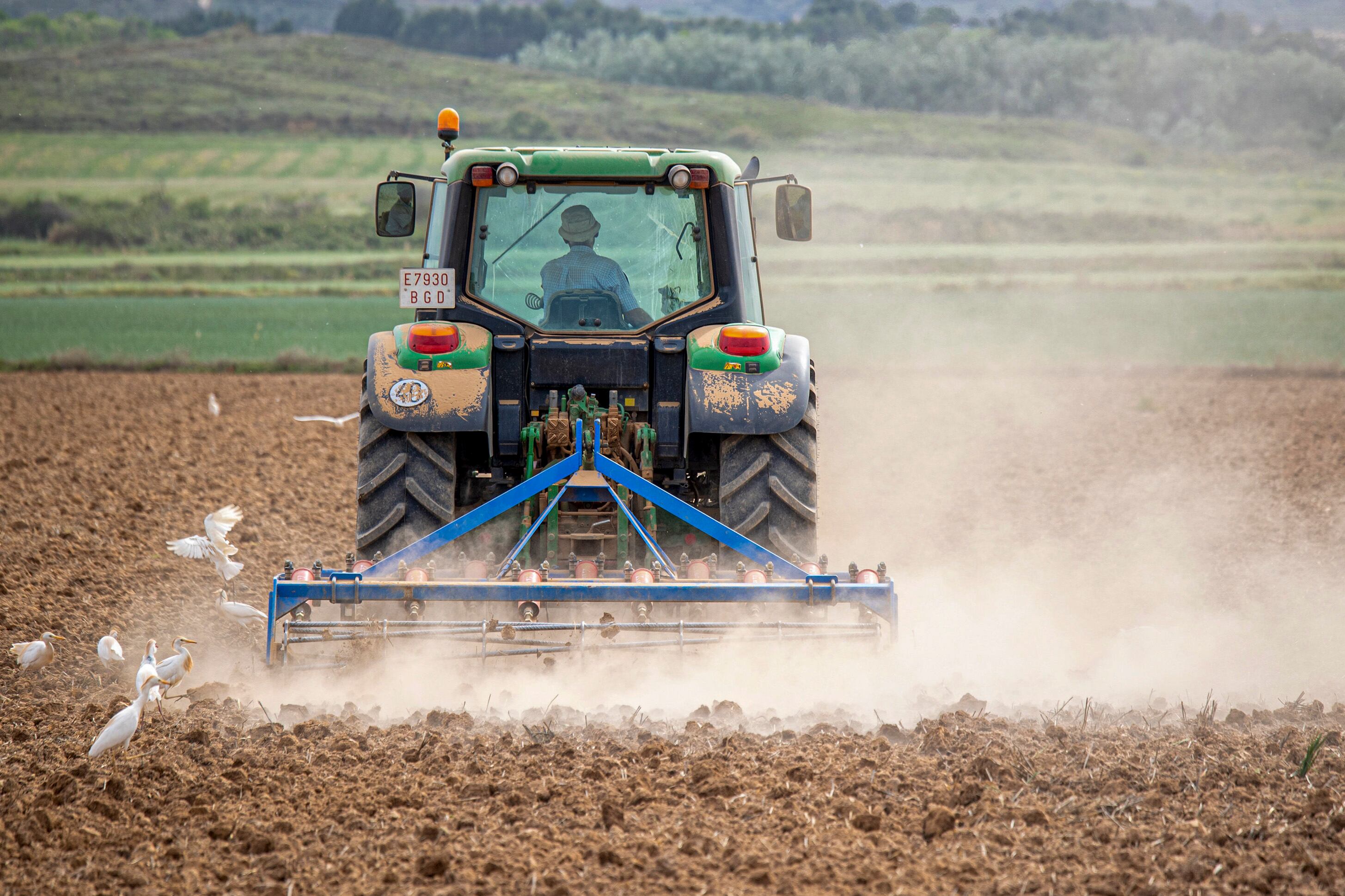 Un agricultor labra con tractor la tierra