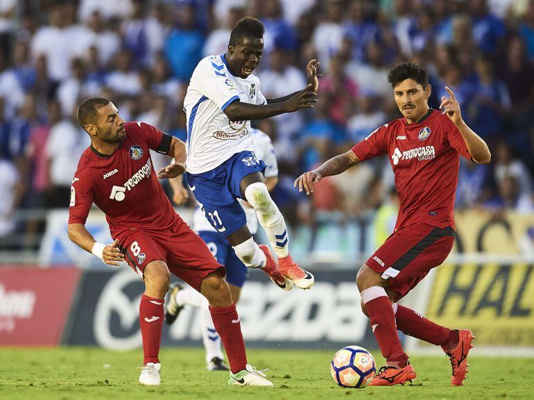 Amath Ndiaye of CD Tenerife (C) being fouled by Alejandro Faurlin of Getafe CF (R) and Mehdi Laceng of Getafe CF (L) during La Liga 2 play off round between CD Tenerife and Getafe CF at Heliodoro Rodriguez Lopez Stadium on June 21, 2017 in Tenerife, Spain