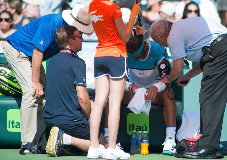 MIA01. MIAMI (EE.UU), 26/03/2016.- El tenista Rafael Nadal (2d) es revisado por un doctor después de retirarse de un juego contra Damir Dzumhur hoy, sábado 26 de marzo de 2016, durante el Abierto de Tenis de Miami en Key Biscayne, Miami, Florida (Estados 