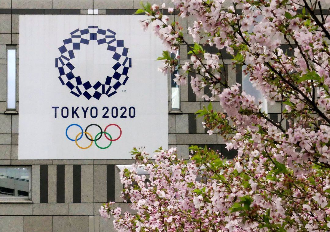 Fotografía de archivo de un cartel con el logotipo de los Juegos Olímpicos de Tokio 2020 junto a un cerezo en flor el 6 de marzo de 2018, en Tokio (Japón).