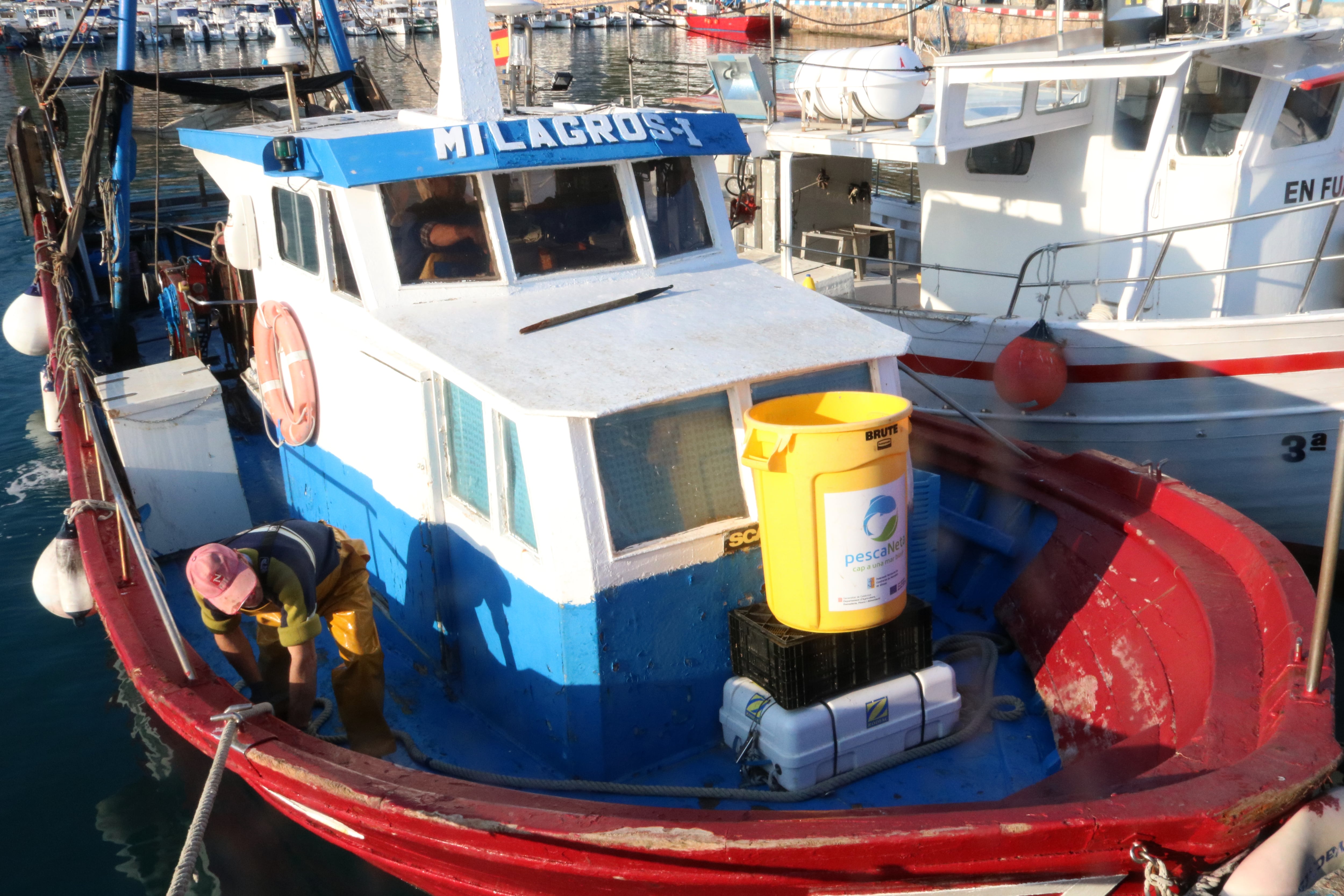 Una embarcació del port de Blanes amb un cubell amb la brossa recollida al mar