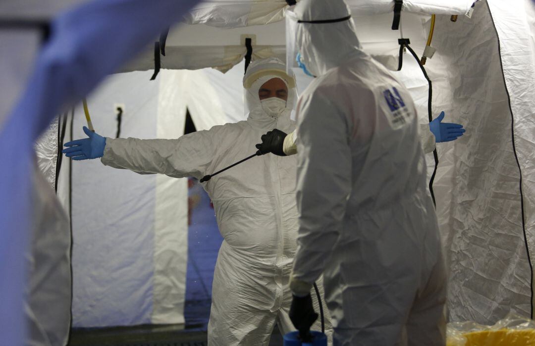 Un trabajador desinfecta a otro en una carpa instalada para luchar contra el coronavirus.
