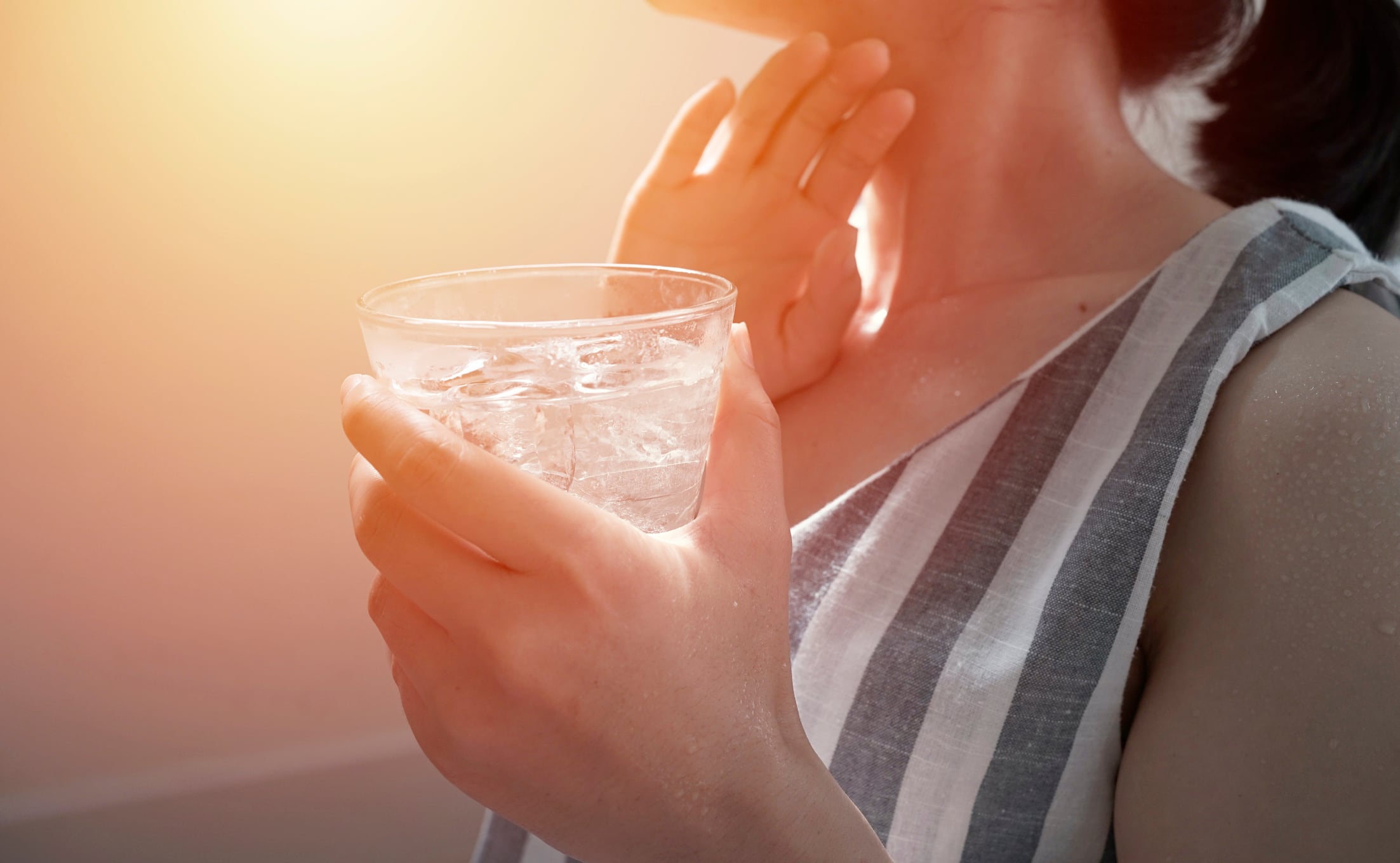 Una mujer bebiendo agua.