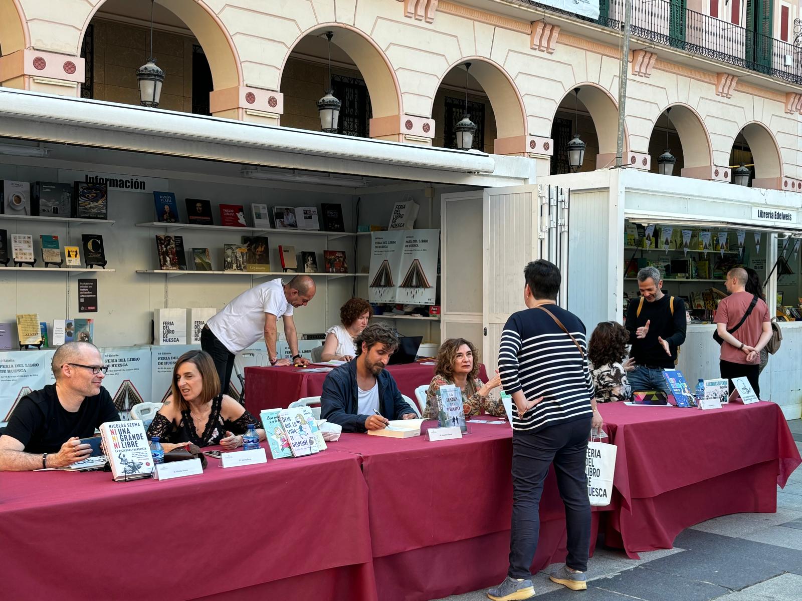 Los autores, firmando sus ejemplares en la Feria del Libro de Huesca